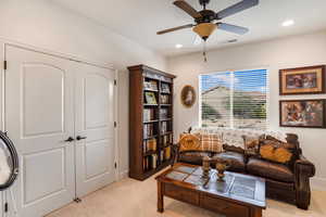 Living area with ceiling fan, light carpet, and recessed lighting