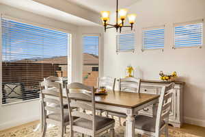 Dining space with hanging lights, light wood-type flooring, and healthy amount of natural light