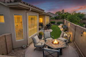 Fenced backyard with a patio area and an outdoor living space with a fire pit