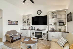 Living room featuring vaulted ceiling and ceiling fan
