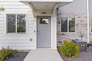 View of exterior entry featuring stone and siding