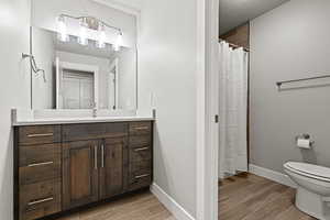 Bathroom with vanity, wood tiled floors, a shower with curtain, and a textured ceiling