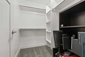 Walk in closet with dark colored carpet