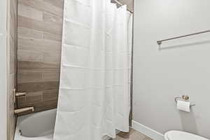 Bathroom featuring shower / bath combo and light wood-type flooring