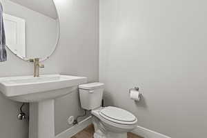 Half Bathroom on first floor with toilet and light wood-style floors