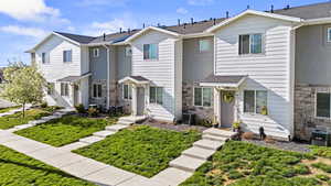 Townhome with stone siding and roof with shingles