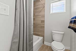 Bathroom featuring shower / bath combo and light wood-style floors