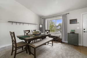 Dining room with vaulted ceiling and light tile patterned floors