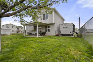 Back of house with a fenced backyard and a patio