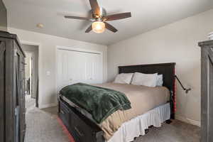 Bedroom featuring a closet, ceiling fan, and light carpet