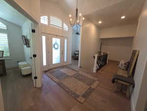 Vaulted entry foyer featuring wood-finish flooring, a chandelier, and recessed lighting