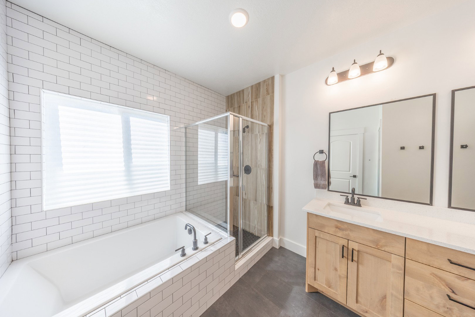 Bathroom with vanity, a stall shower, and a garden tub