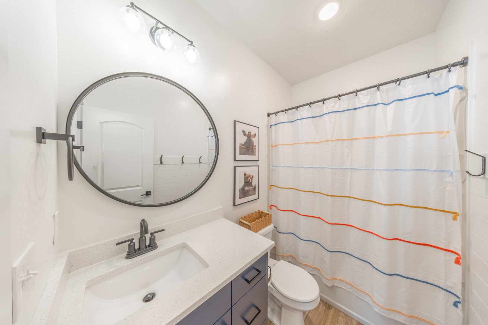 Full bath featuring vanity, shower / bathtub combination with curtain, and light wood-style floors