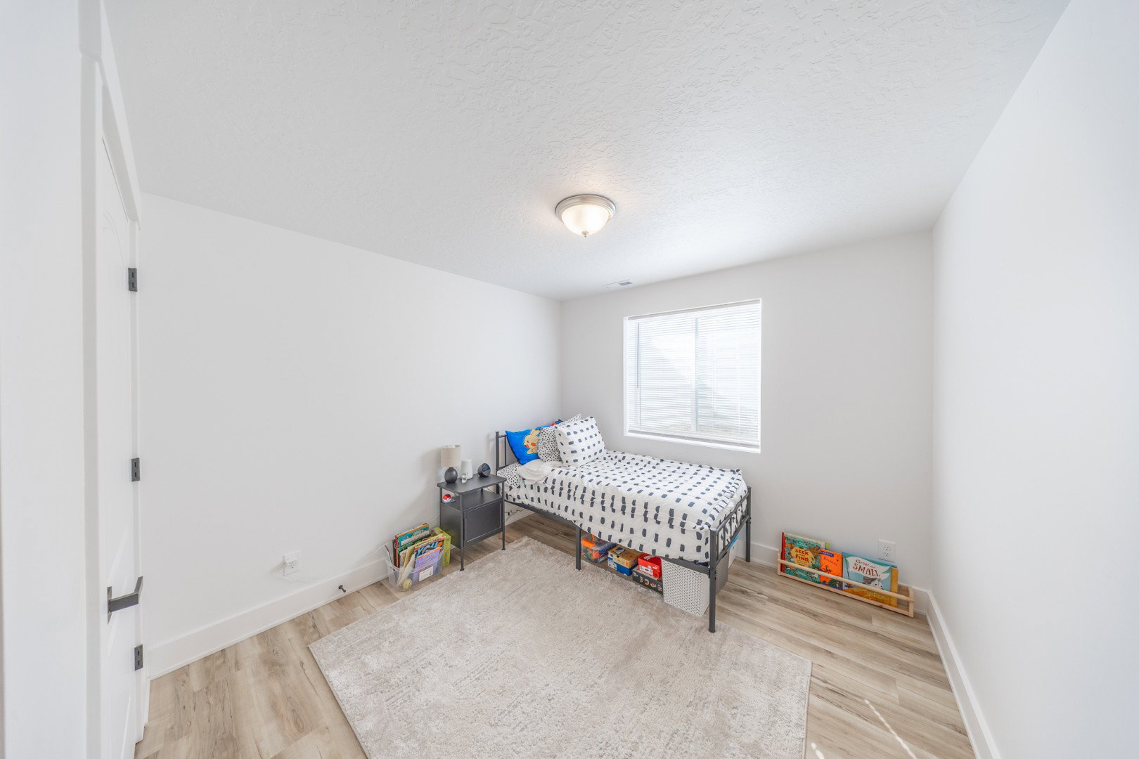 Bedroom with light wood-style flooring and a textured ceiling