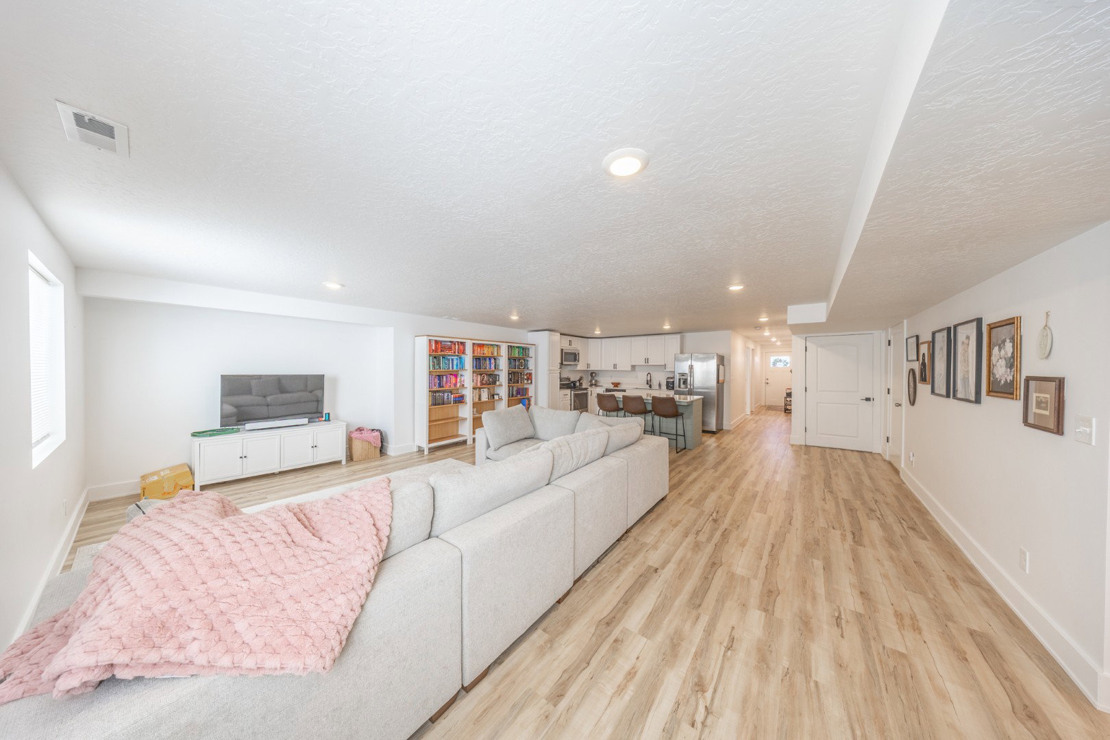 Living room featuring light wood-type flooring, a textured ceiling, and recessed lighting