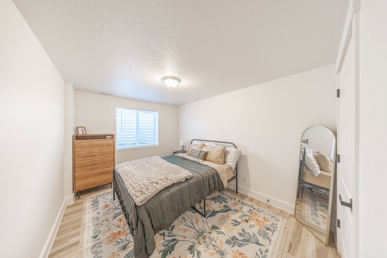 Bedroom with a textured ceiling and light wood finished floors