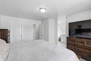 Bedroom with a textured ceiling and ensuite bath