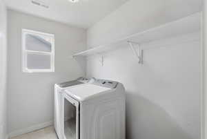 Laundry room with washing machine and clothes dryer and baseboards