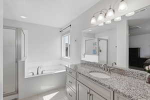 Ensuite bathroom with a shower stall, a bath, vanity, and light tile patterned floors