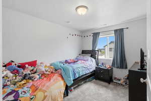 Bedroom featuring light carpet and a textured ceiling