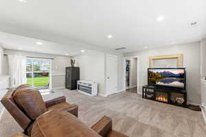 Living area with light colored carpet and recessed lighting