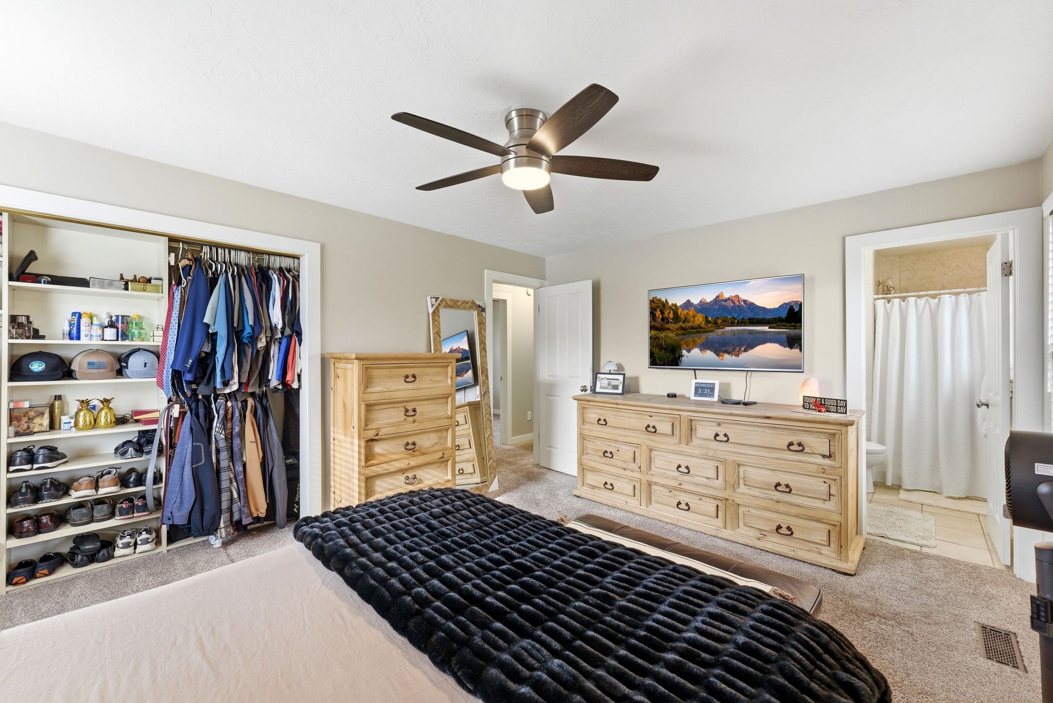 Bedroom with light carpet, a closet, and ceiling fan