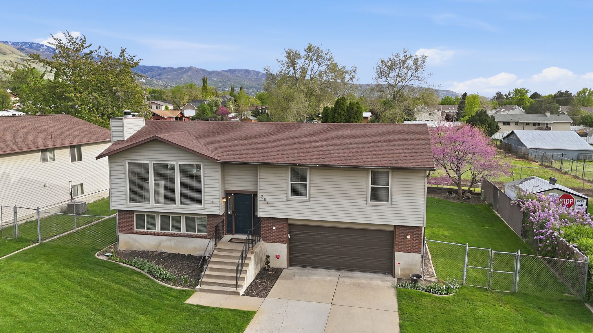 Split foyer home with brick siding, a gate, driveway, a garage, and a mountain view