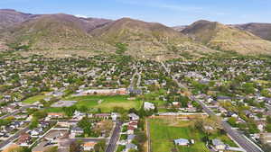 Aerial view of residential area with property parcel outlined and mountains