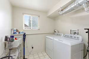 Laundry area with light floors and washing machine and dryer
