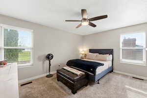 Bedroom with a ceiling fan and light carpet