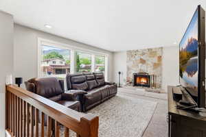 Carpeted living room with a fireplace and recessed lighting