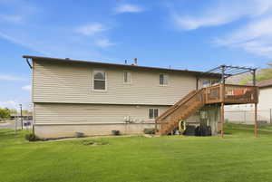 Rear view of property featuring a yard and a deck