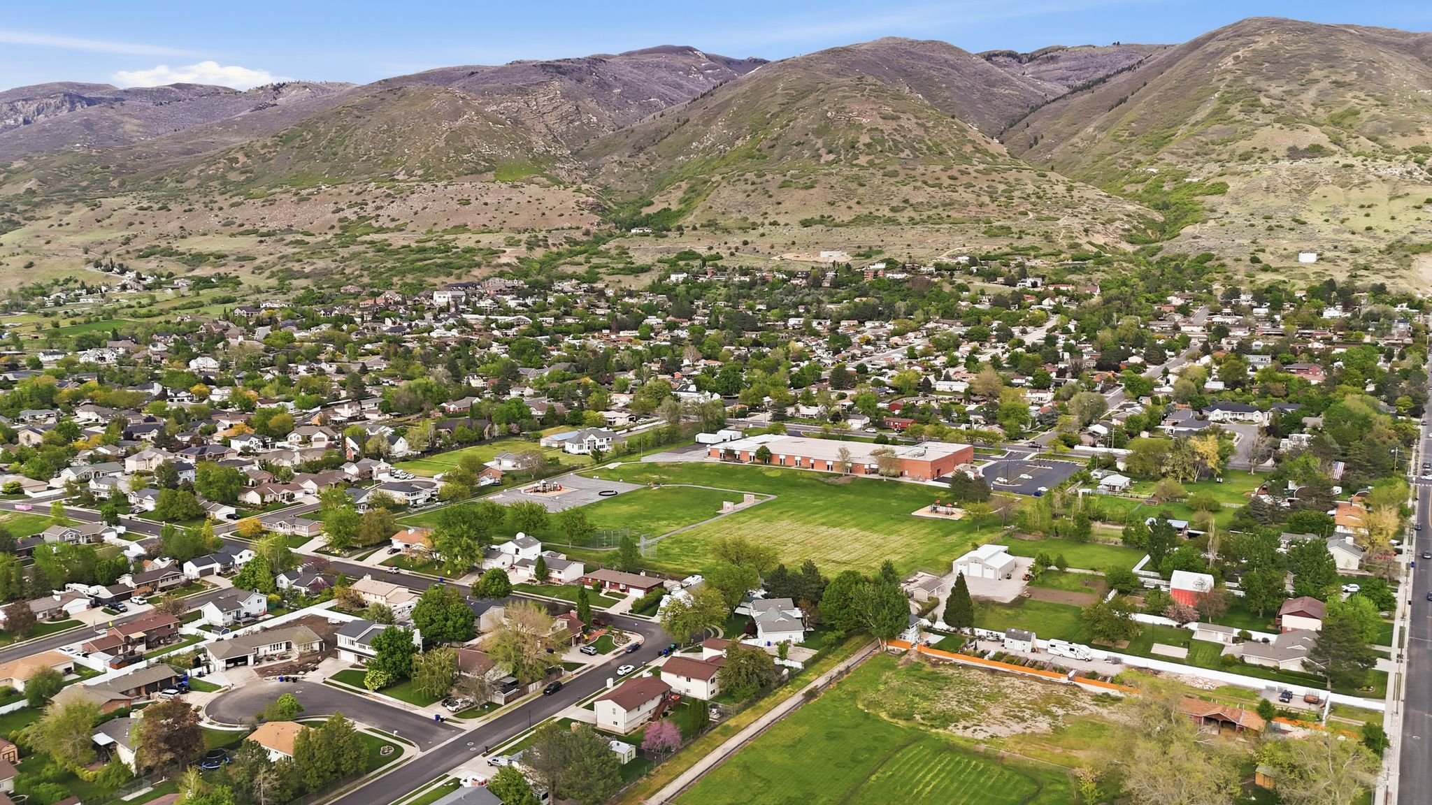 Aerial view of residential area featuring property parcel outlined and a mountain backdrop