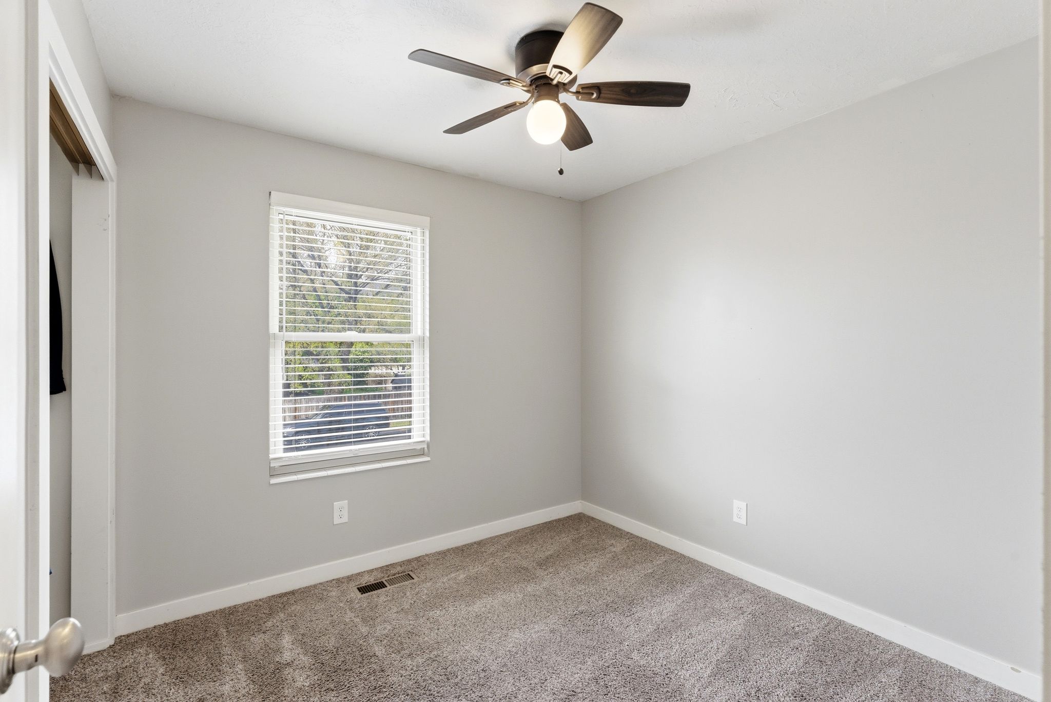 Spare room with light colored carpet and a ceiling fan