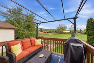 Wooden deck featuring a yard, area for grilling, an outdoor living space, and a mountain view