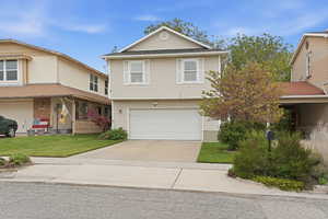 View of front facade with driveway, a garage, and a front lawn