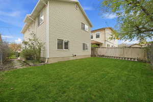 Rear view of house with a fenced backyard