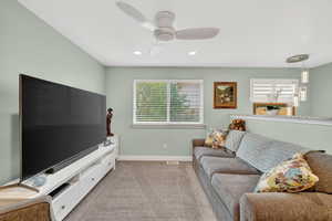 Living room with light carpet, recessed lighting, and a ceiling fan