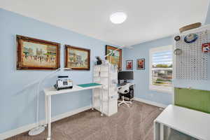 Office space with light carpet and baseboards