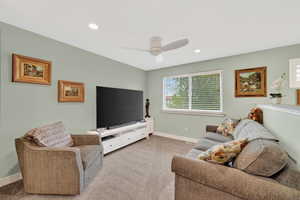 Living area with light carpet, recessed lighting, and a ceiling fan