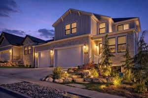 View of front of house featuring driveway, board and batten siding, and an attached garage