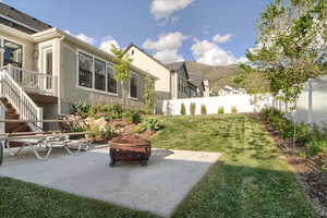 Fenced backyard featuring a patio, a fire pit, and a mountain view
