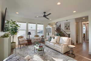 Living area featuring wood finished floors, ceiling fan, and recessed lighting