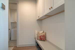Mudroom with washer / clothes dryer and light wood-style flooring