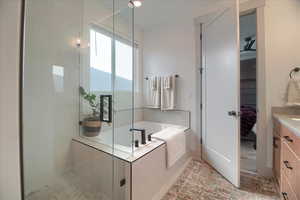 Ensuite bathroom featuring a garden tub, vanity, and a shower stall