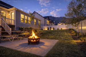 Fenced backyard with a patio area, a fire pit, and a mountain view