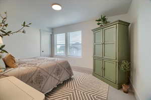 Bedroom featuring light colored carpet and baseboards