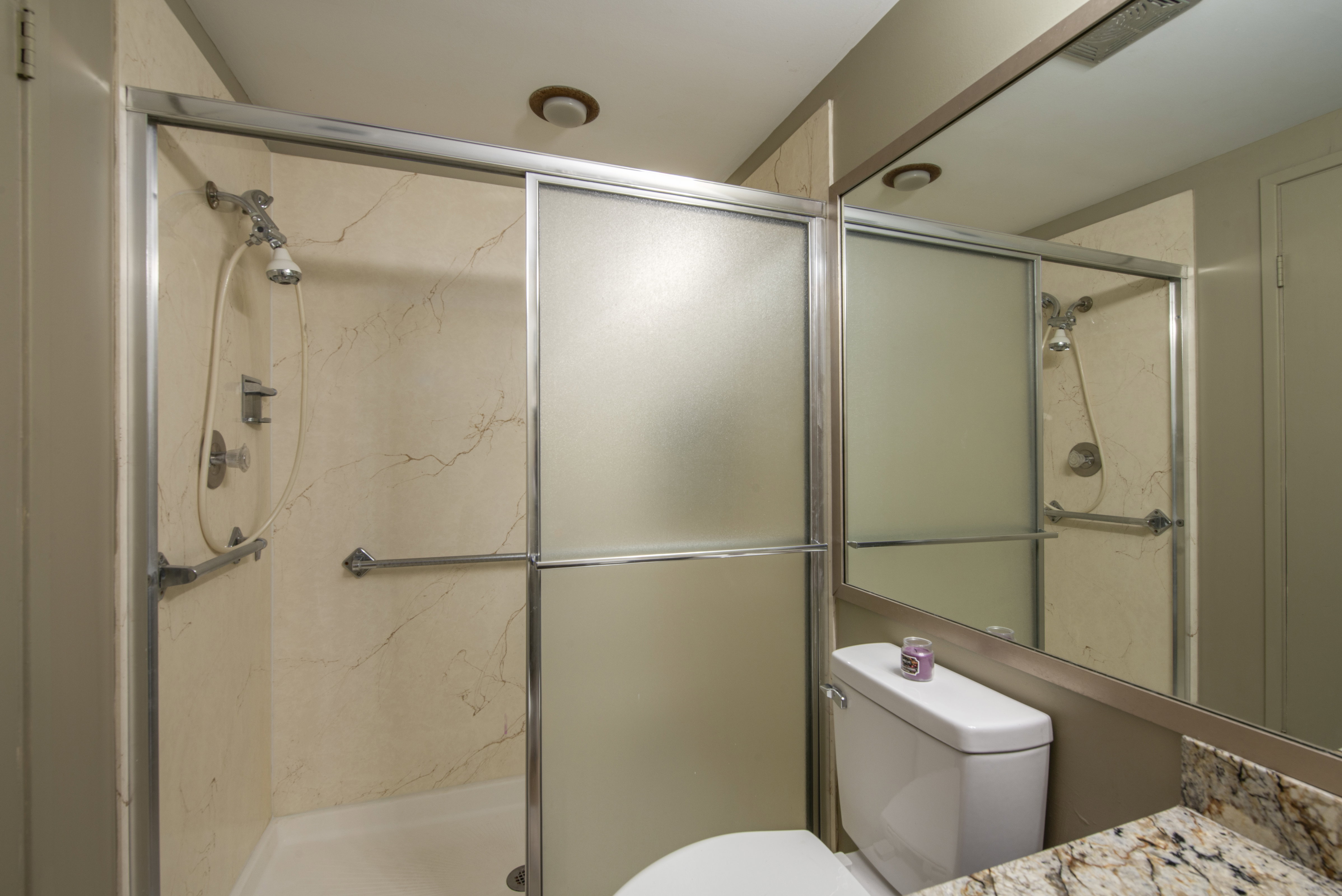 Full bath featuring vanity and a marble finish shower