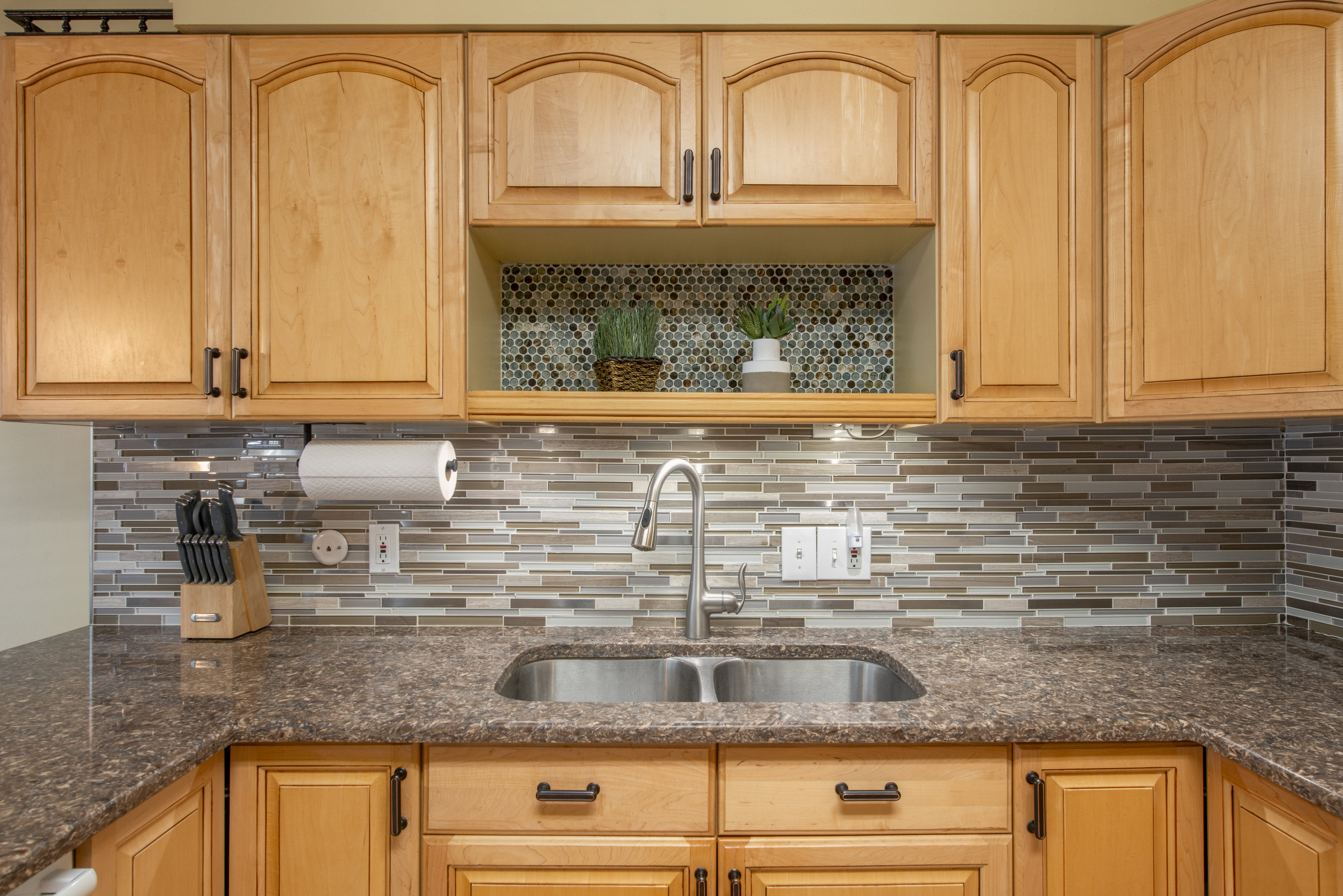 Kitchen with dark stone countertops and light wood finish cabinetry