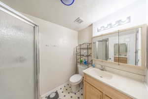 Bathroom with vanity, a shower stall, and light floors